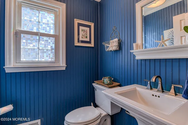 a bathroom with a sink a toilet and mirror