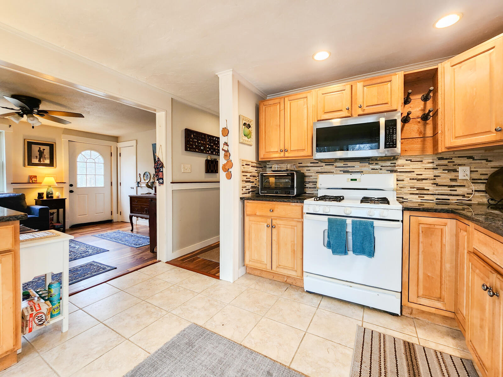 437 Cotuit Road Mashpee, MA 02649 - Photo 7 of 30 a kitchen with a stove top oven a sink dishwasher and a refrigerator with wooden floor