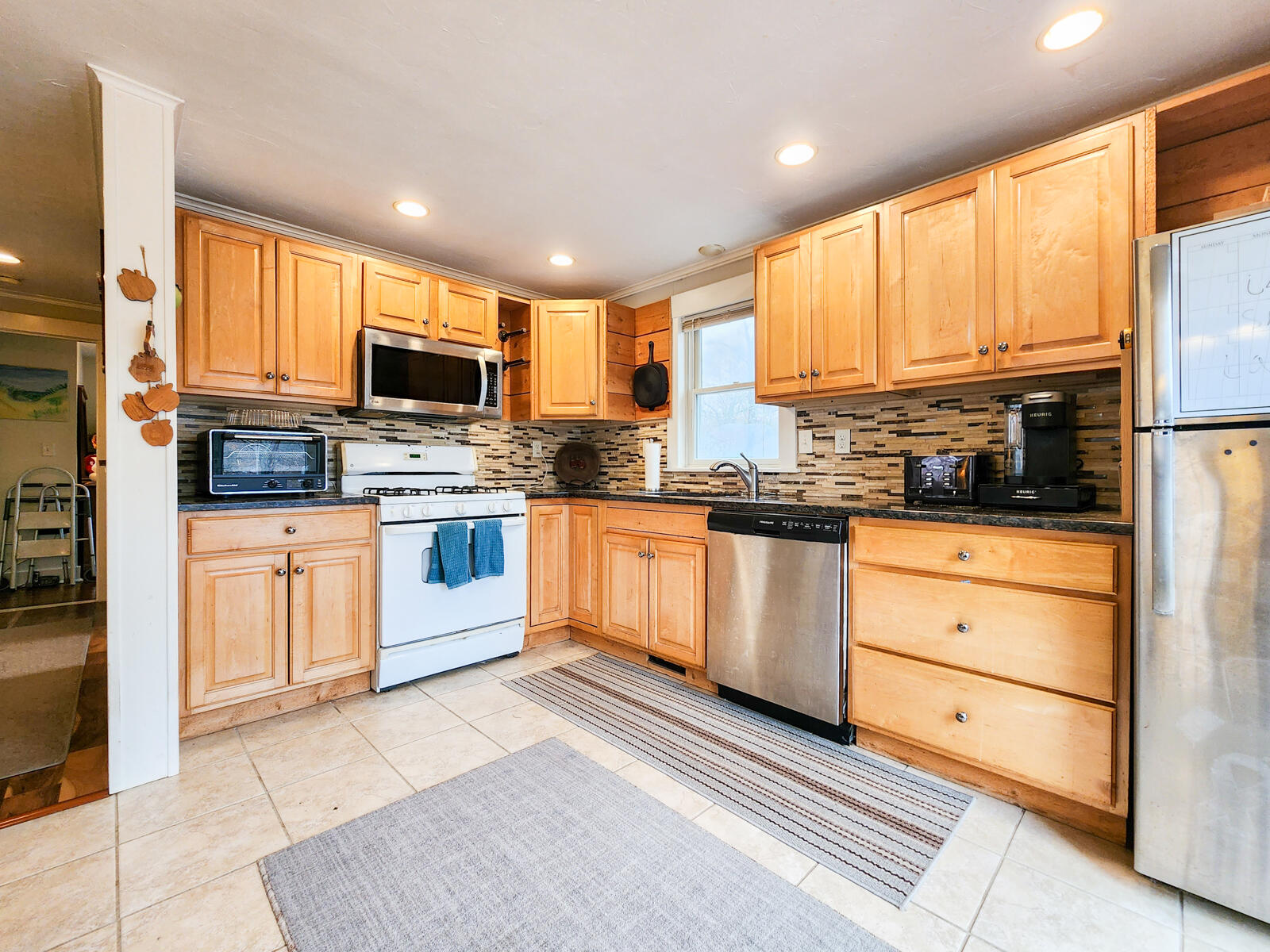 437 Cotuit Road Mashpee, MA 02649 - Photo 9 of 30 a kitchen with stainless steel appliances granite countertop a stove top oven and a refrigerator
