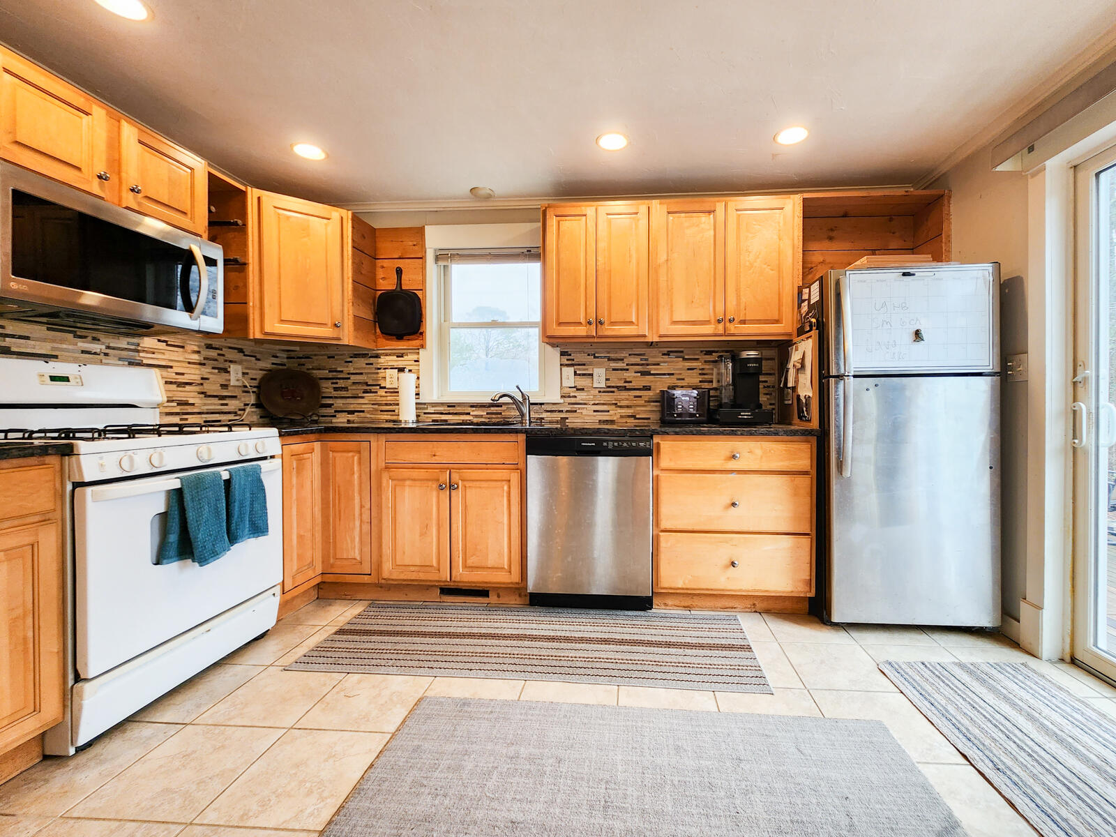 437 Cotuit Road Mashpee, MA 02649 - Photo 10 of 30 a kitchen with stainless steel appliances granite countertop a stove a refrigerator and a microwave