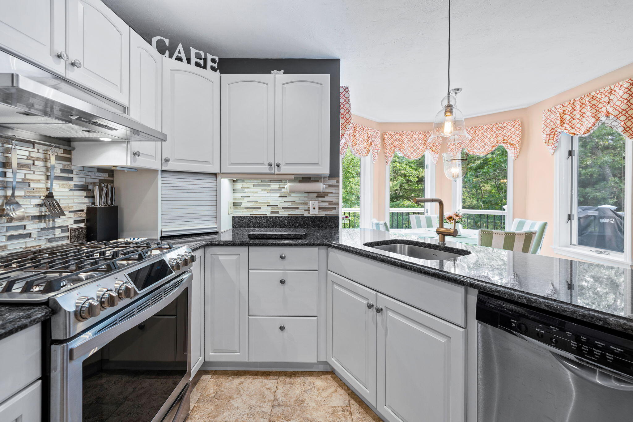 363 Blacksmith Shop Road East Falmouth, MA 02536 - Photo 11 of 40 a kitchen with stainless steel appliances a stove a sink and a white cabinets