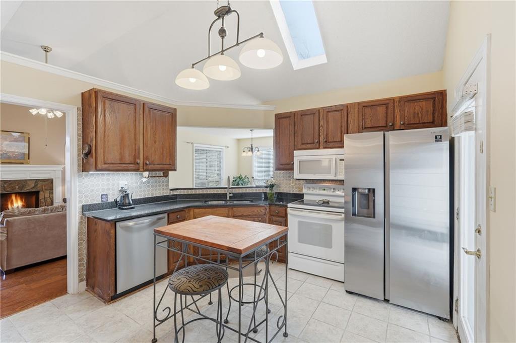 2240 McBrayer Court Cumming, GA 30028 - Photo 11 of 35 a kitchen with stainless steel appliances granite countertop a sink a stove a refrigerator cabinets and a center island