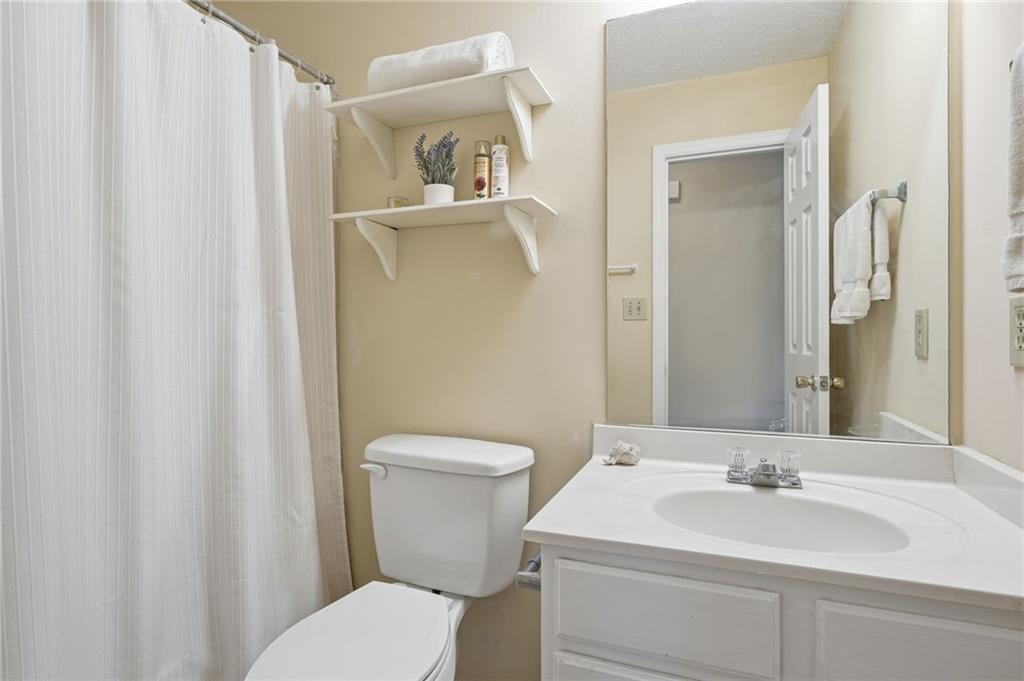 2240 McBrayer Court Cumming, GA 30028 - Photo 23 of 35 a bathroom with a sink a toilet and a mirror