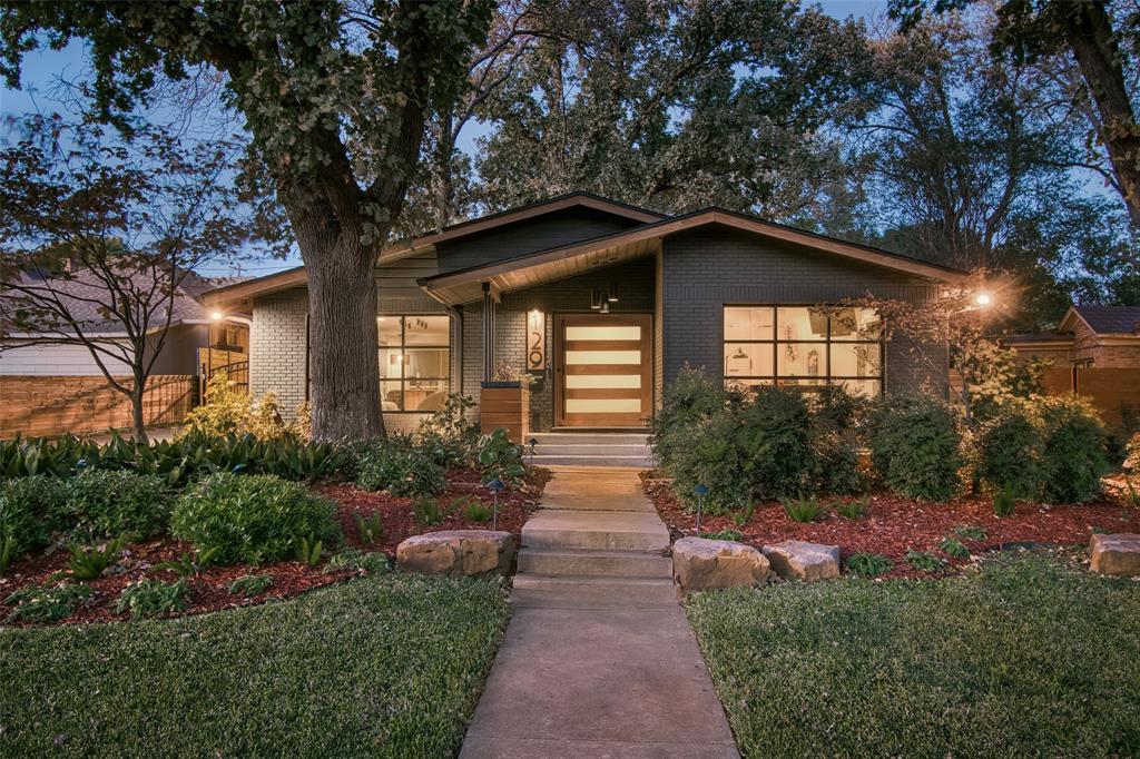 a front view of a house with a yard and trees