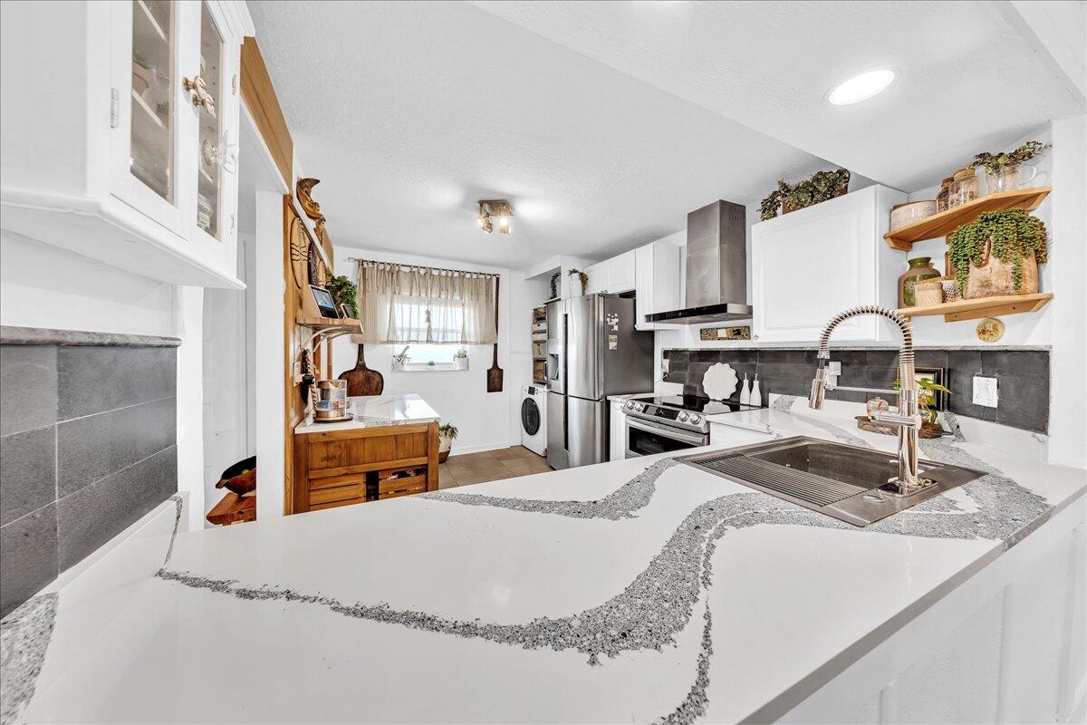 1523 East Hillsboro Boulevard, Unit 531 Deerfield Beach, FL 33441 - Photo 15 of 71 a large bed sitting in a bedroom and kitchen