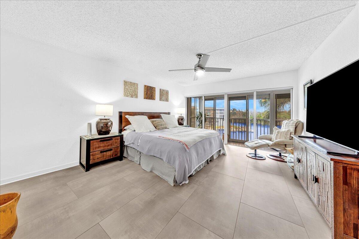 1523 East Hillsboro Boulevard, Unit 531 Deerfield Beach, FL 33441 - Photo 31 of 71 a spacious bedroom with a bed and a flat screen tv