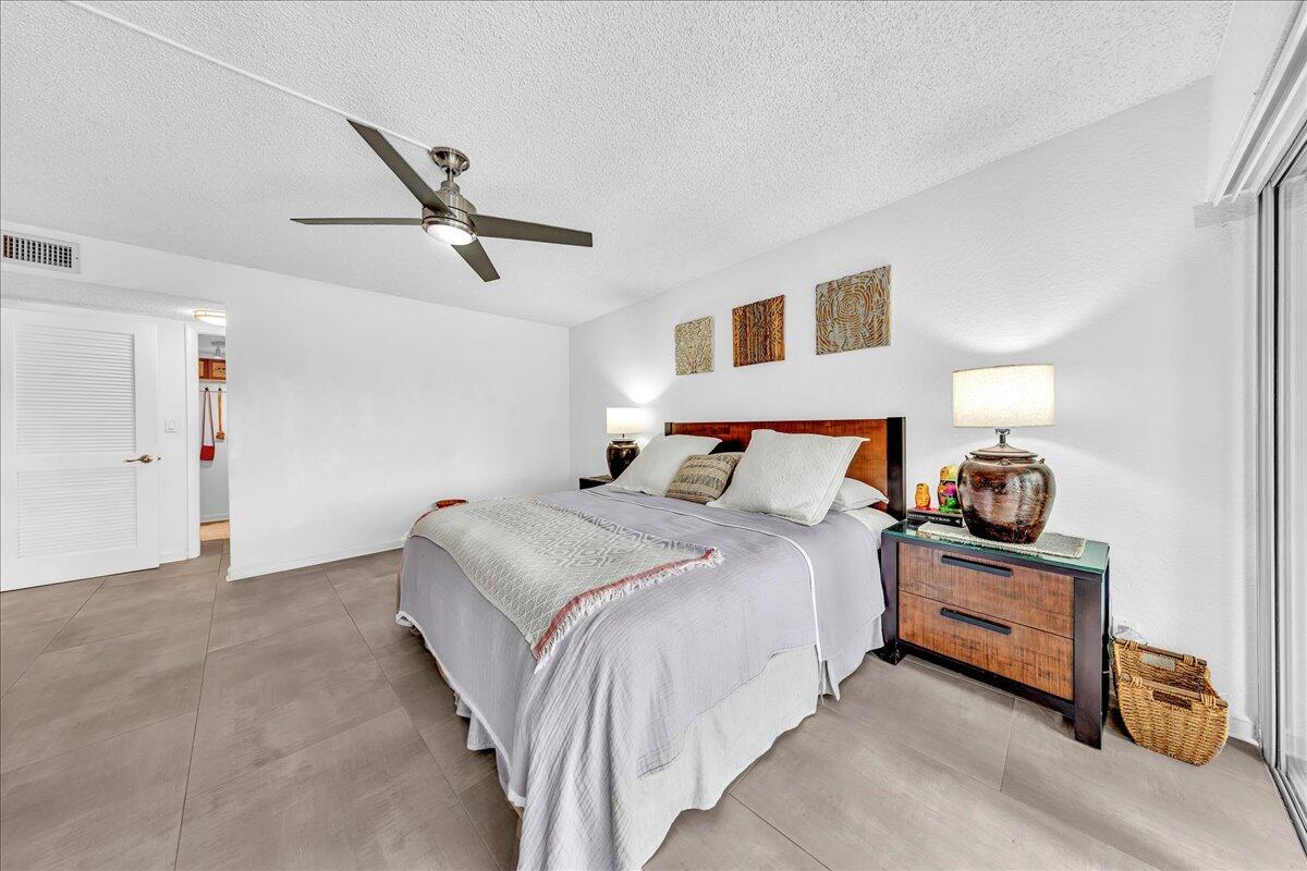 1523 East Hillsboro Boulevard, Unit 531 Deerfield Beach, FL 33441 - Photo 33 of 71 a bedroom with a bed and a chandelier