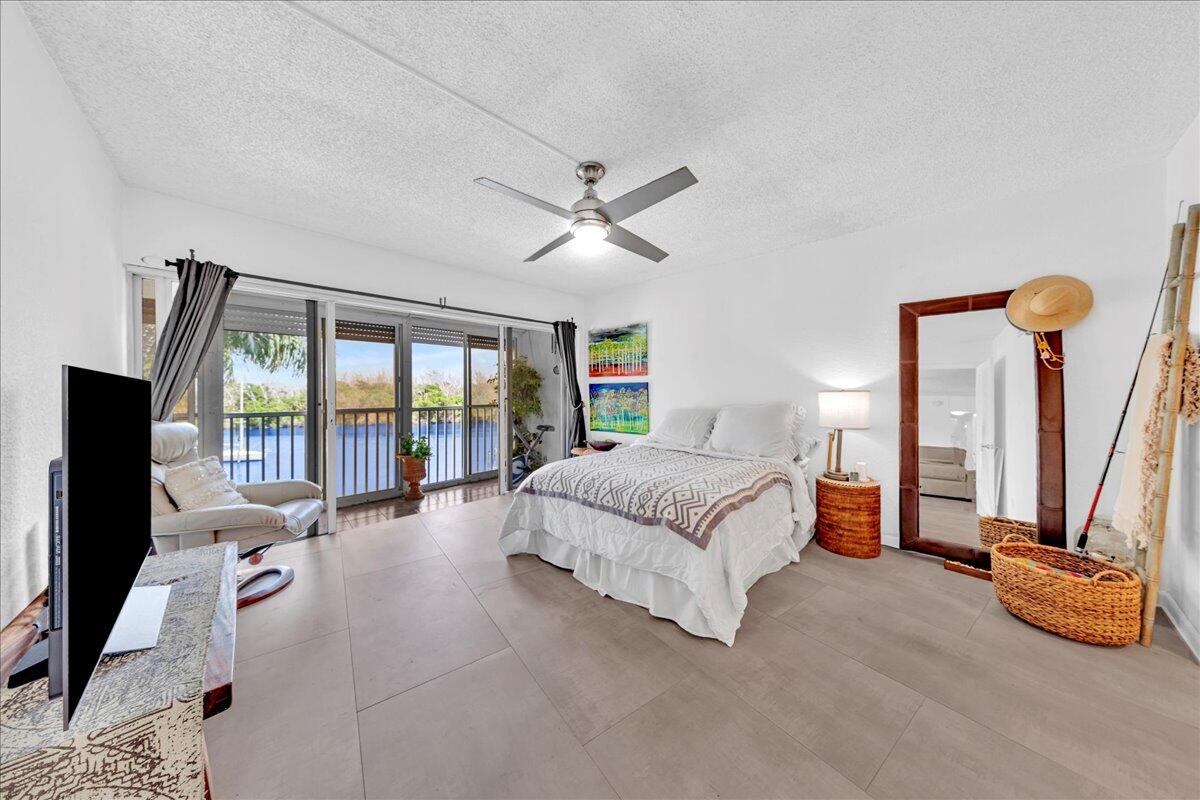 1523 East Hillsboro Boulevard, Unit 531 Deerfield Beach, FL 33441 - Photo 42 of 71 a spacious bedroom with a bed a couch and a flat tv screen on dresser