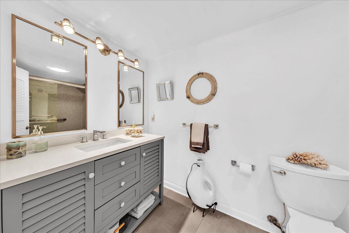 1523 East Hillsboro Boulevard, Unit 531 Deerfield Beach, FL 33441 - Photo 47 of 71 a bathroom with a granite countertop sink mirror and a toilet