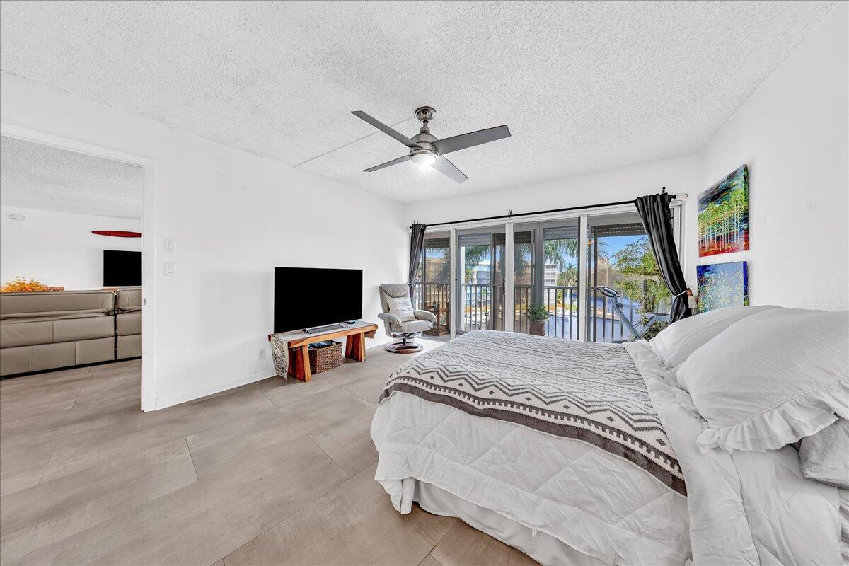 1523 East Hillsboro Boulevard, Unit 531 Deerfield Beach, FL 33441 - Photo 48 of 71 a bedroom with a bed and a flat screen tv