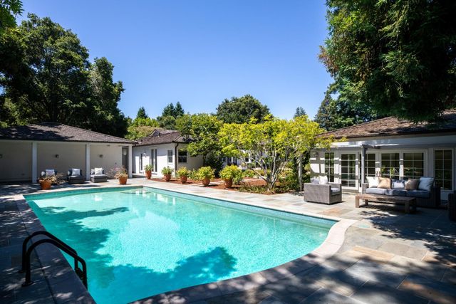 a view of a house with swimming pool and sitting area