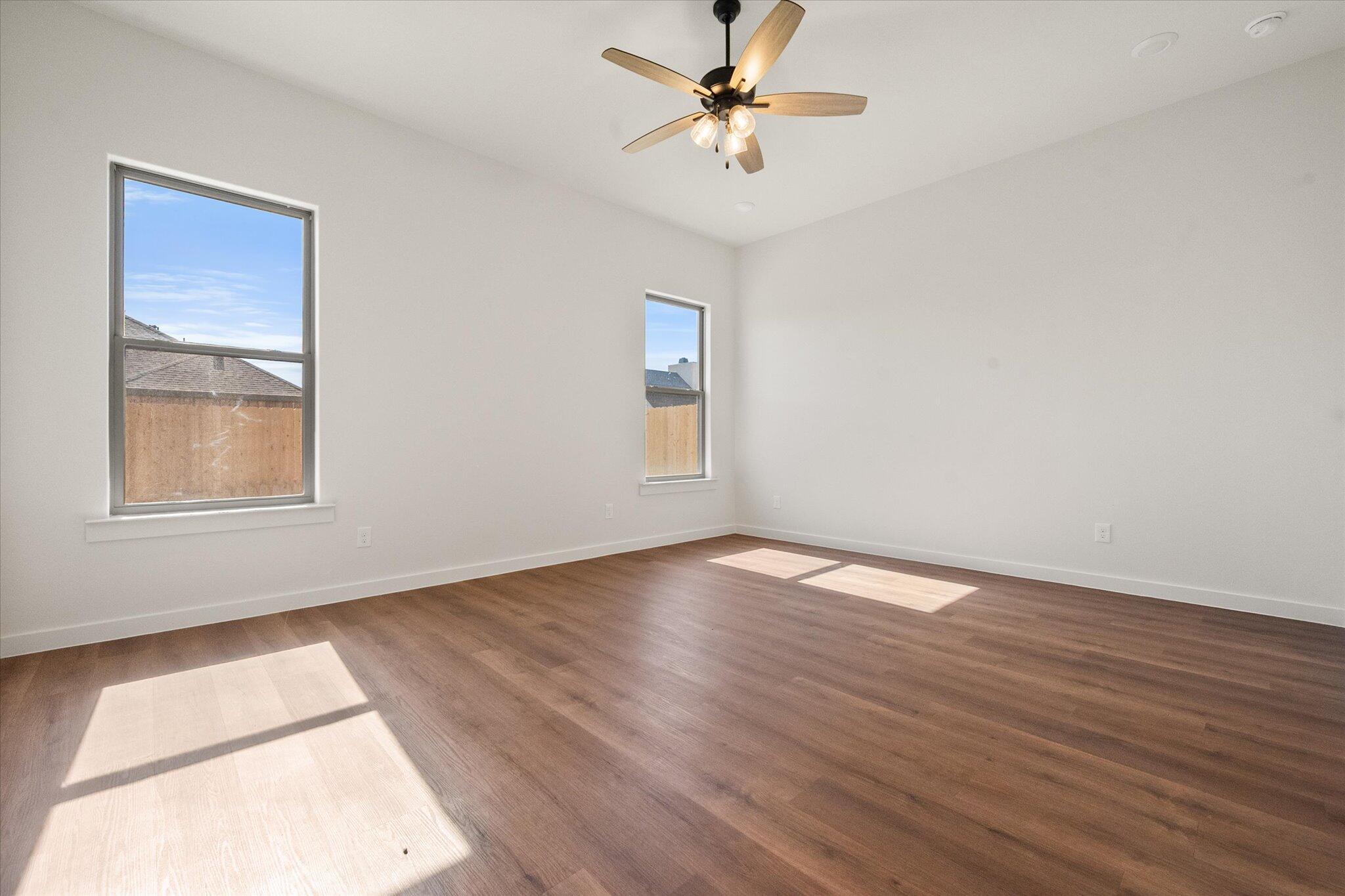 7007 16th Street Lubbock, TX 79416 - Photo 12 of 24 a view of an empty room with wooden floor and a window