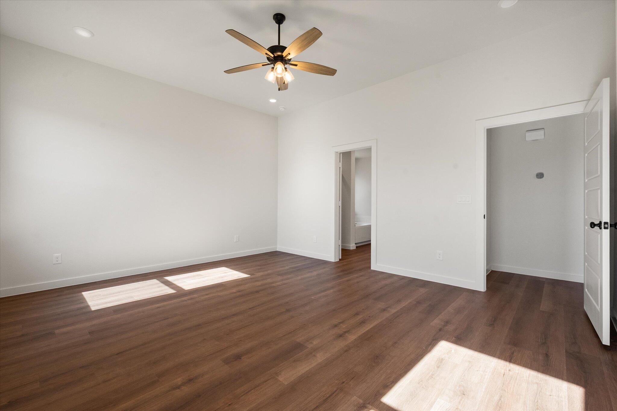 7007 16th Street Lubbock, TX 79416 - Photo 13 of 24 an empty room with wooden floor and a ceiling fan