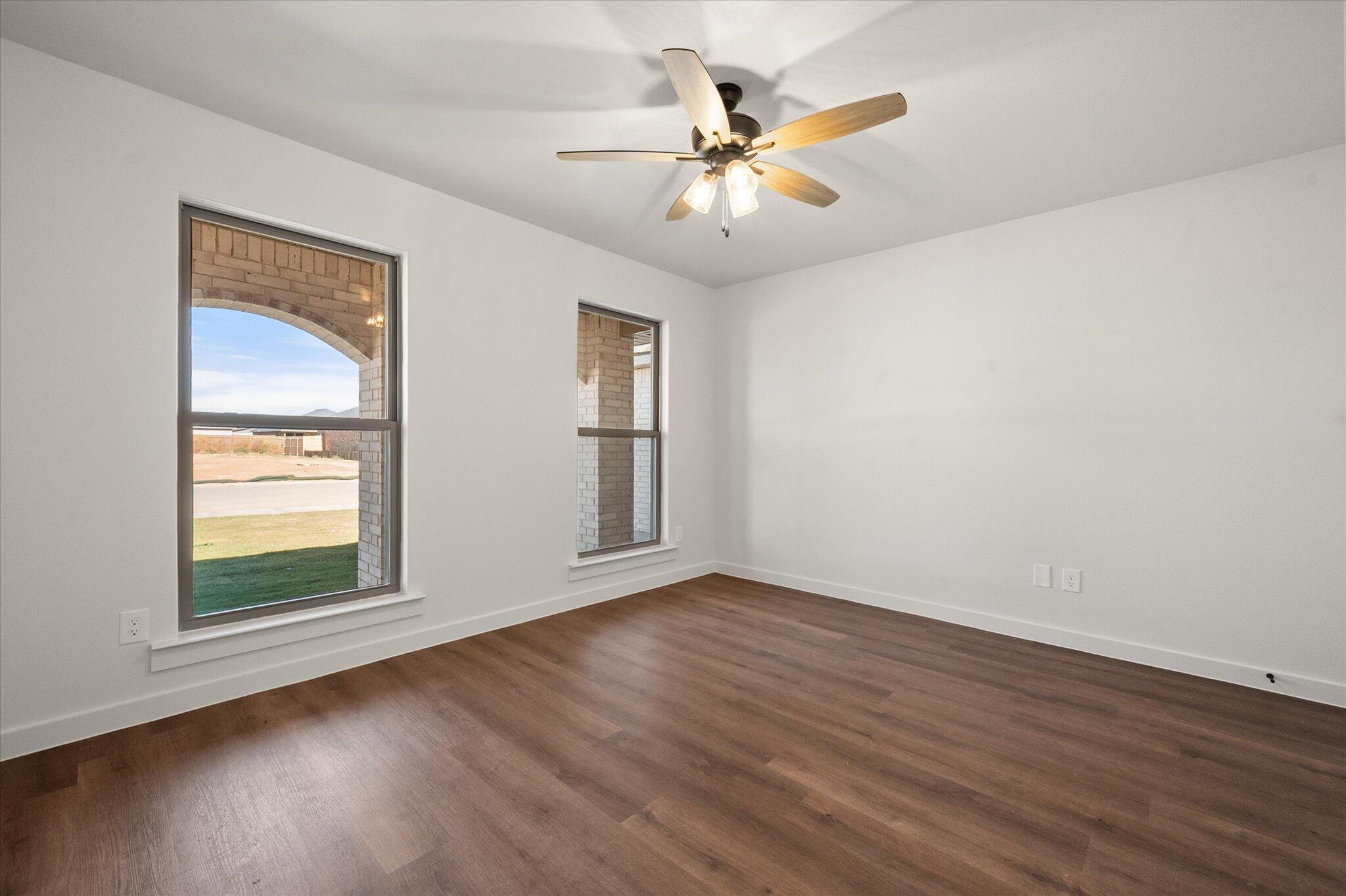 7007 16th Street Lubbock, TX 79416 - Photo 19 of 24 a view of an empty room with wooden floor and a window