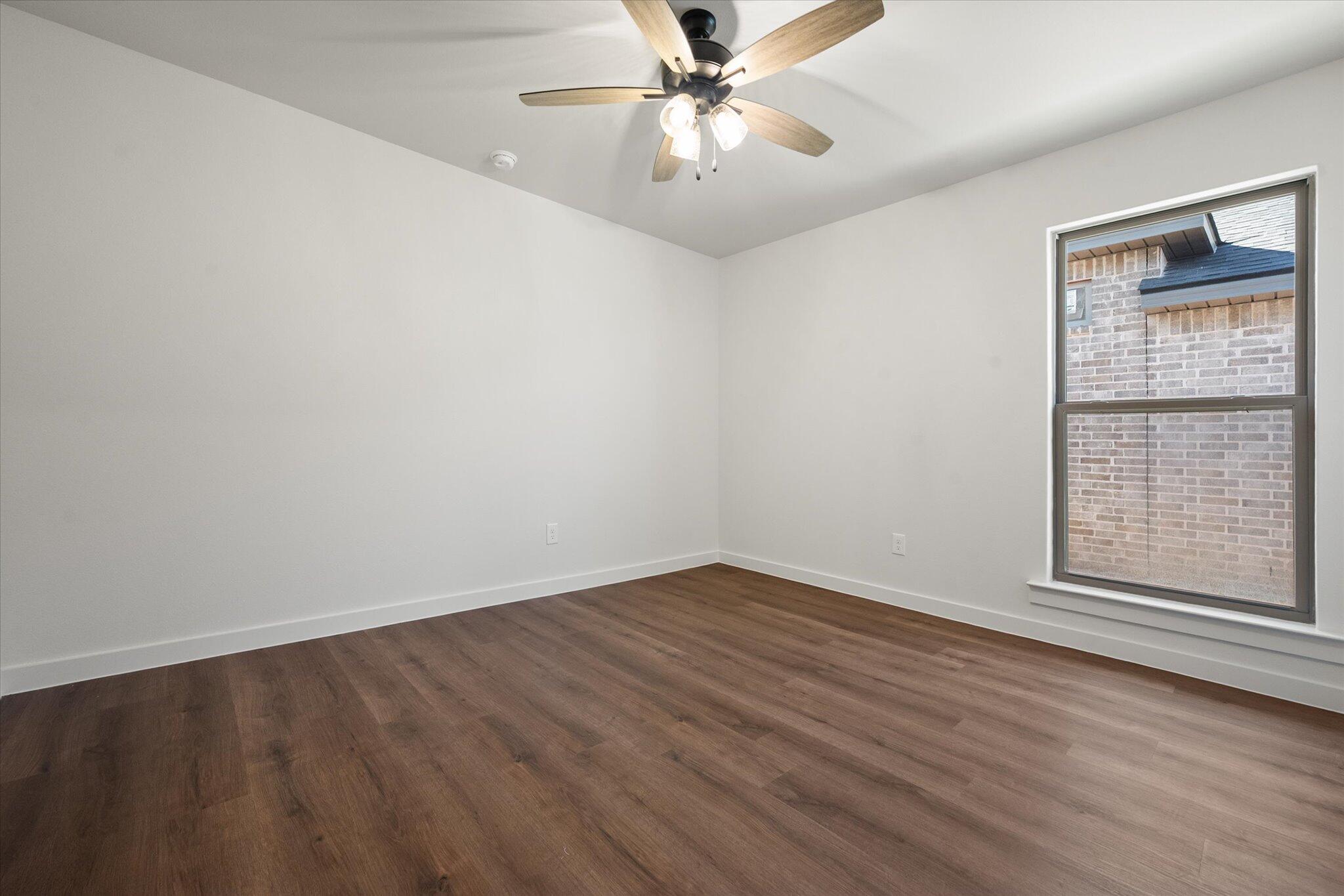 7007 16th Street Lubbock, TX 79416 - Photo 20 of 24 wooden floor in an empty room with a window