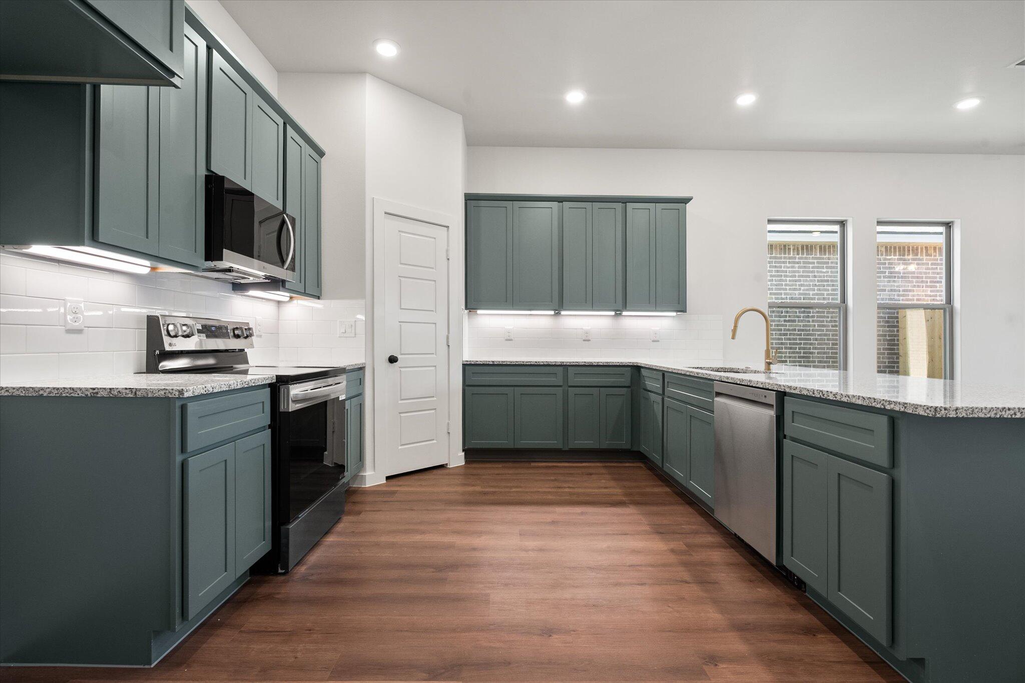 7007 16th Street Lubbock, TX 79416 - Photo 4 of 24 a kitchen with stainless steel appliances kitchen island granite countertop a sink and cabinets