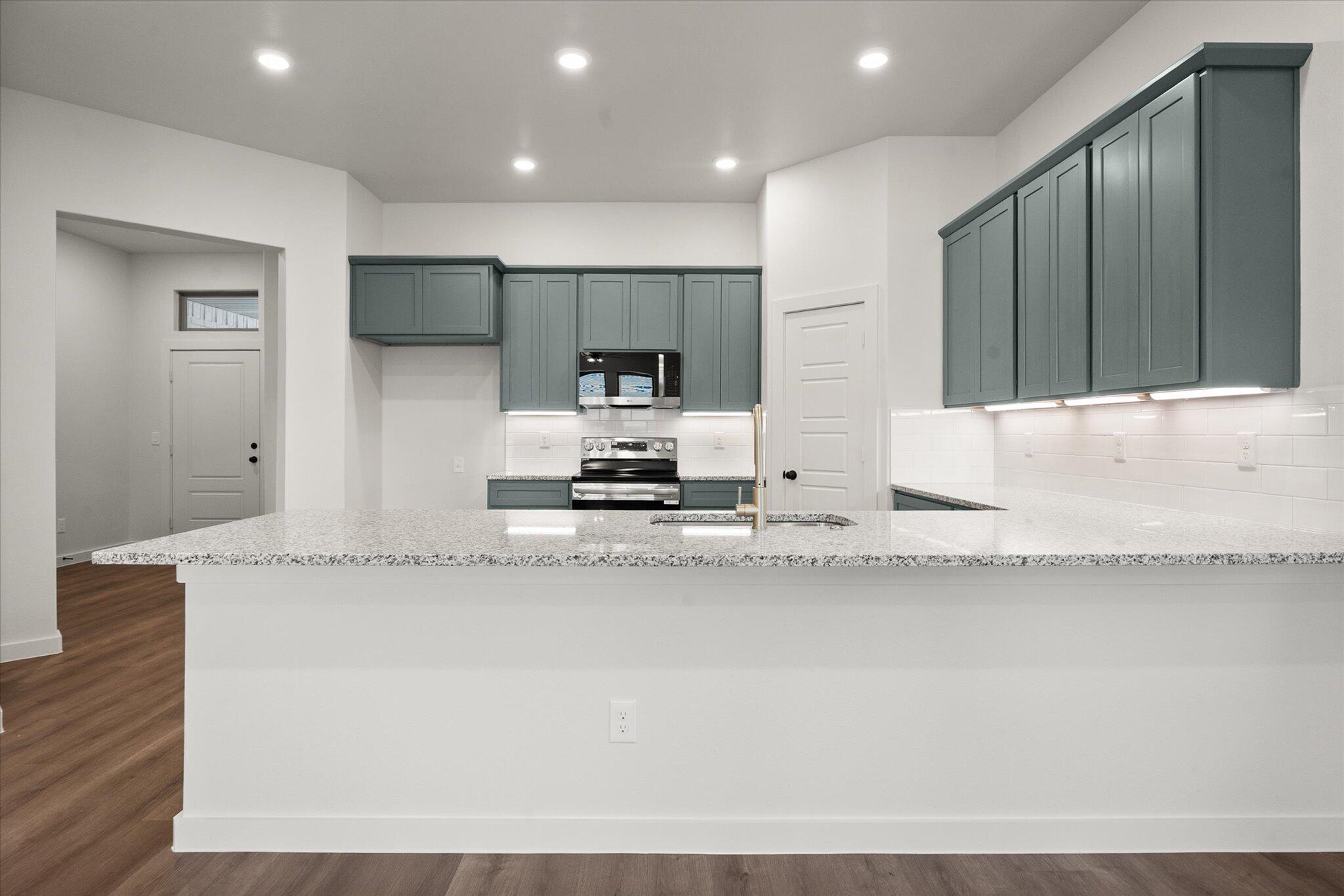 7007 16th Street Lubbock, TX 79416 - Photo 6 of 24 a kitchen with stainless steel appliances granite countertop a sink a stove and a refrigerator