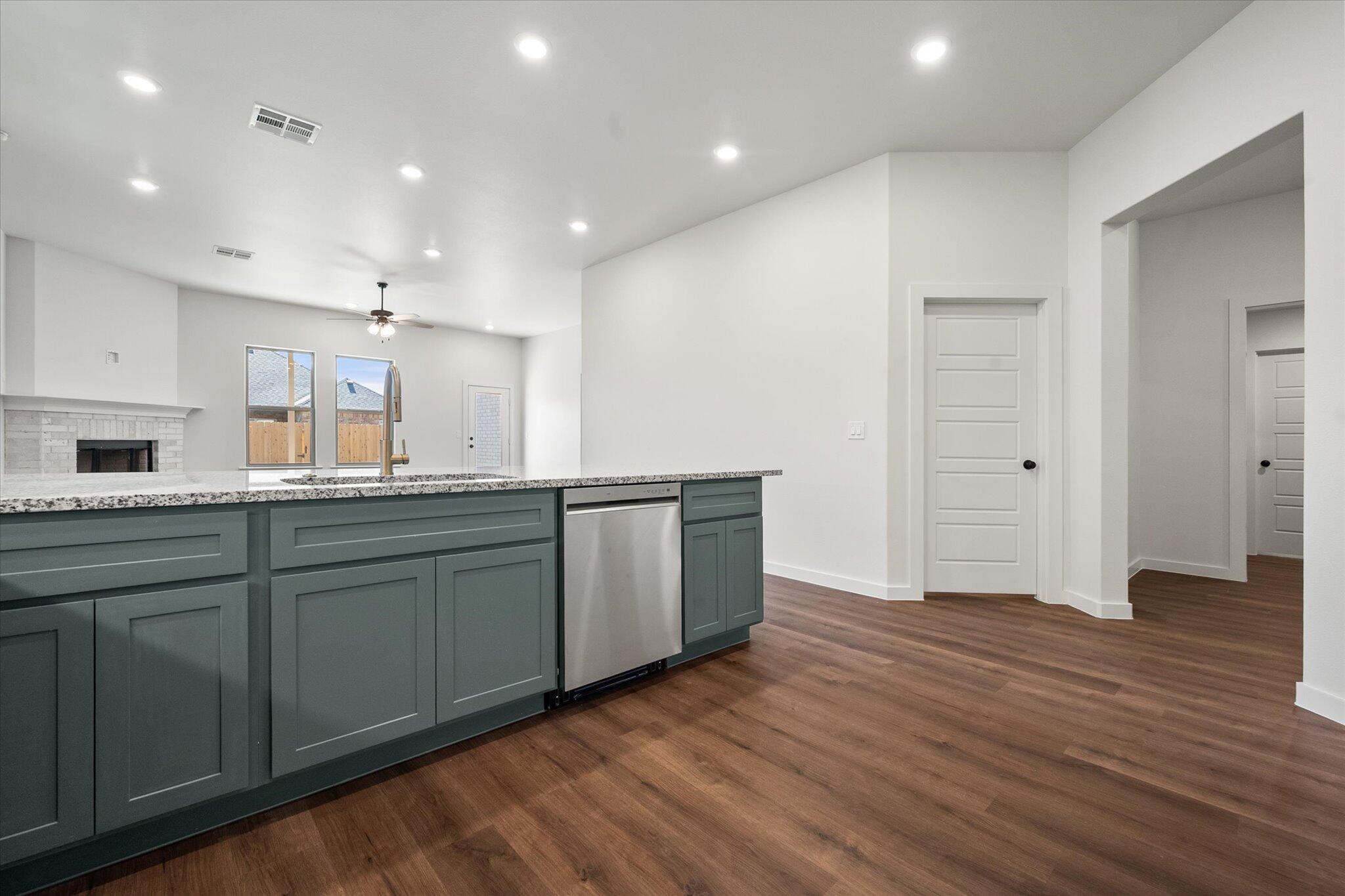 7007 16th Street Lubbock, TX 79416 - Photo 7 of 24 a open kitchen with kitchen island wooden floors appliances and cabinets