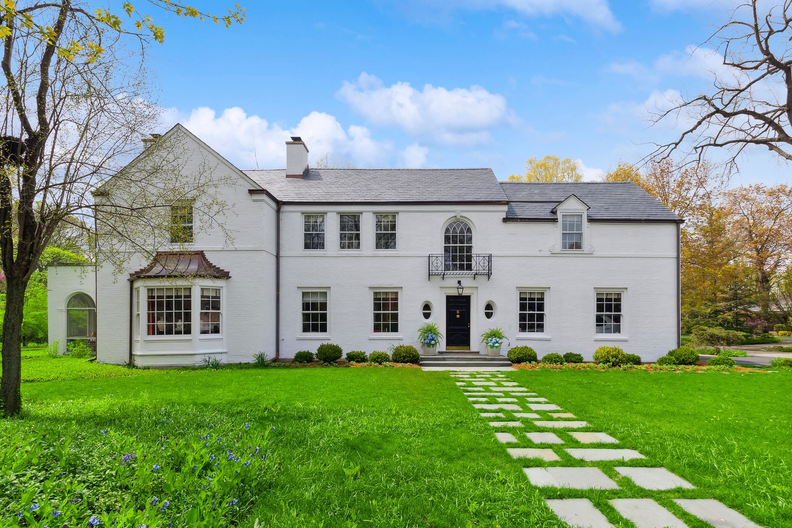 a front view of a house with a yard and trees