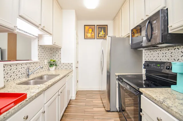 a kitchen with granite countertop a sink and a stove