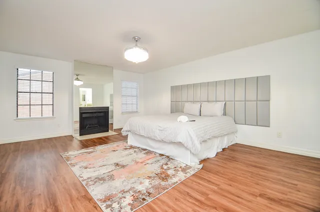 a spacious bedroom with a bed and a flat screen tv