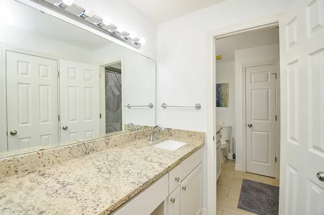 a bathroom with a granite countertop sink and a mirror