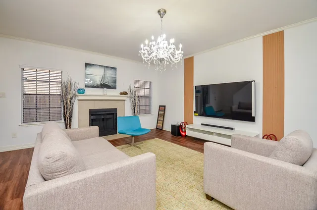 a living room with furniture a flat screen tv and a fireplace