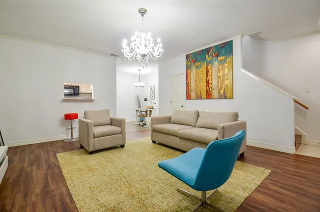a living room with furniture and a chandelier