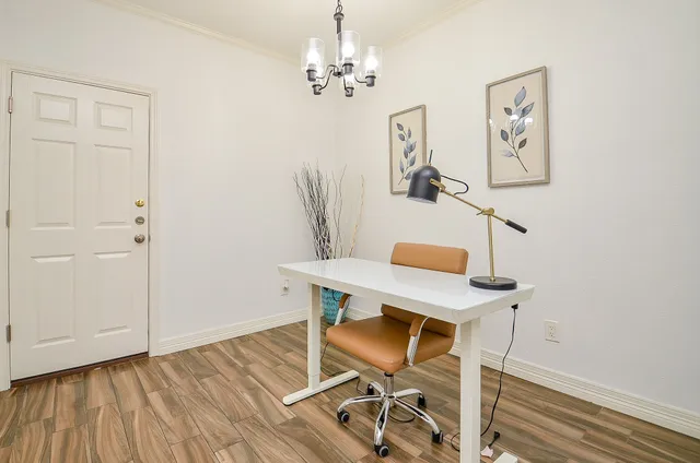 a view of a workspace with furniture and wooden floor