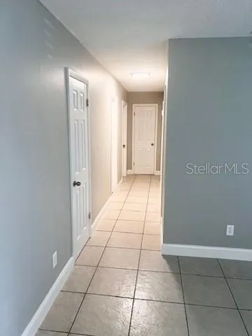 a view of hallway with a window and a refrigerator