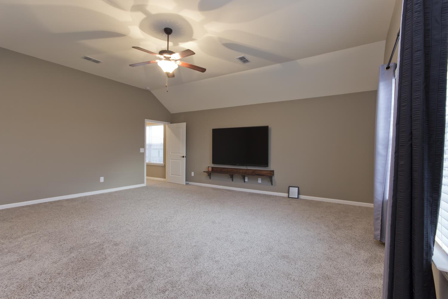 1011 Kyle Road Spring Hill, TN 37174 - Photo 22 of 30 a view of an empty room with a flat screen tv and a chandelier fan