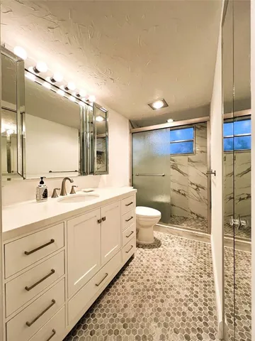 a bathroom with a double vanity sink mirror and toilet