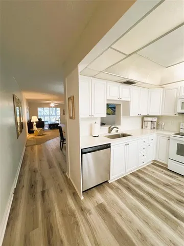 a kitchen with granite countertop cabinets stainless steel appliances a sink and a window