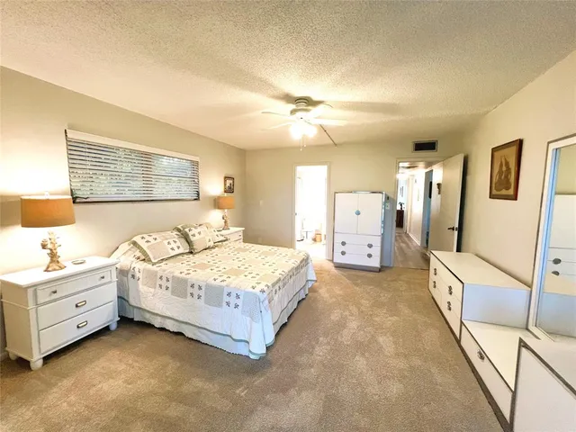 a spacious bedroom with a bed and a chandelier