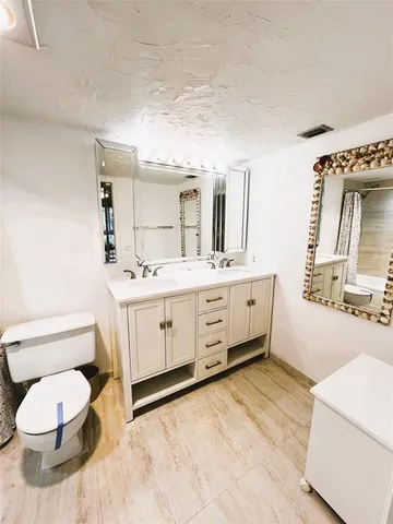 a bathroom with a sink a toilet and mirror