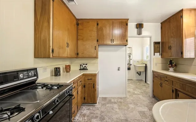 a large kitchen with stainless steel appliances granite countertop a sink stove and refrigerator