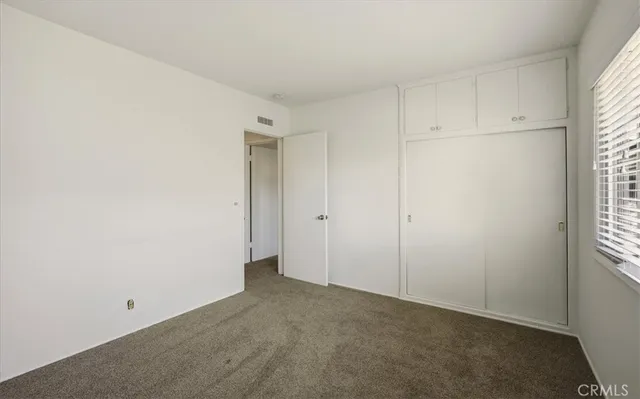 a view of an empty room with closet area