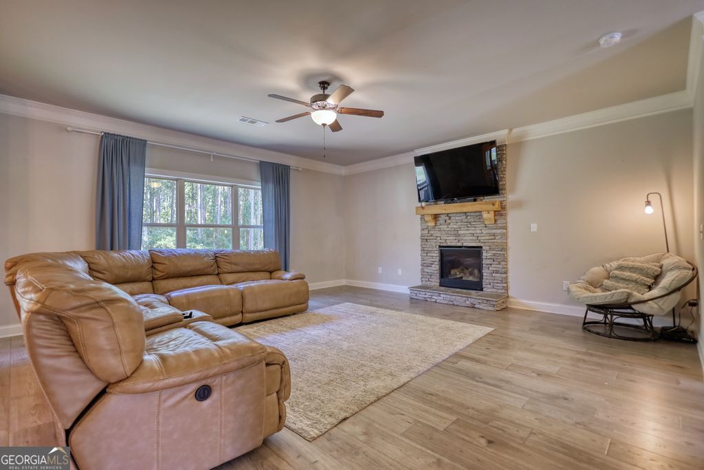 83 Bella Drive Monroe, GA 30655 - Photo 11 of 33 a living room with furniture a flat screen tv and a fireplace