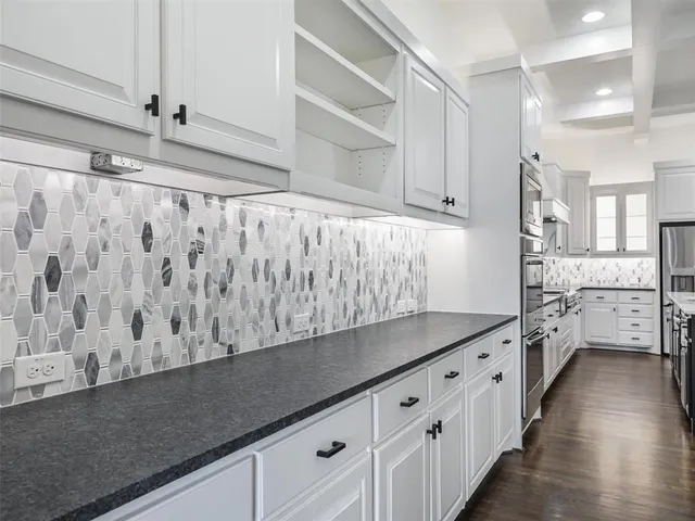 a kitchen with granite countertop white cabinets and white appliances