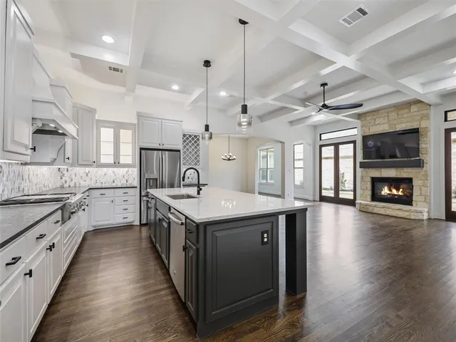 a kitchen with stainless steel appliances granite countertop lots of counter top space and wooden floors