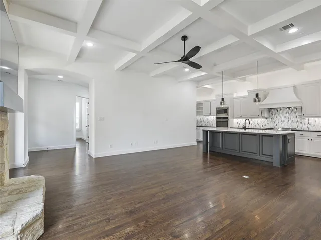 a large white kitchen with a large counter top appliances and cabinets