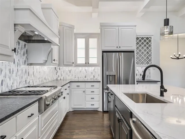 a kitchen with granite countertop a sink stainless steel appliances and cabinets