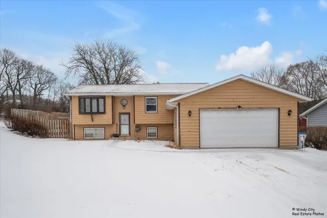 a view of house with a yard and garage