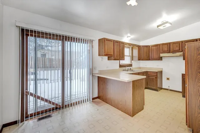 a kitchen with a refrigerator sink and cabinets