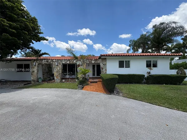a view of a house with a backyard and a tree