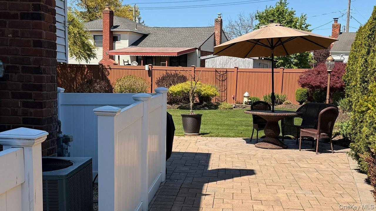 345 O'Connor Road North Babylon, NY 11703 - Photo 14 of 47 a view of a patio with a table and chairs under an umbrella