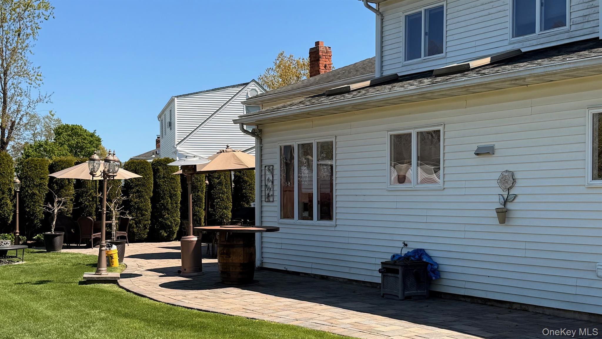345 O'Connor Road North Babylon, NY 11703 - Photo 22 of 47 a view of a patio with a table and chairs under an umbrella