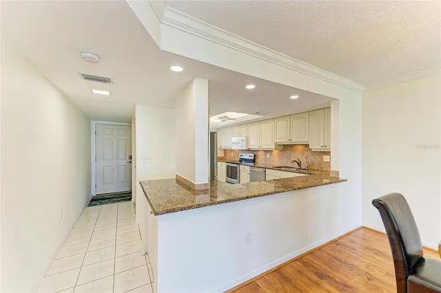 a kitchen with stainless steel appliances granite countertop a refrigerator and a stove