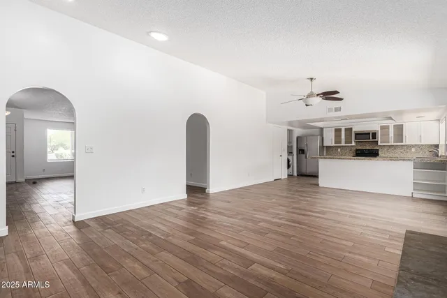 a view of a livingroom with a kitchen counter tops and wooden floor