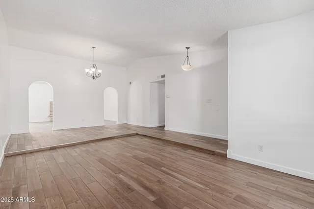 an empty room with wooden floor and bathroom